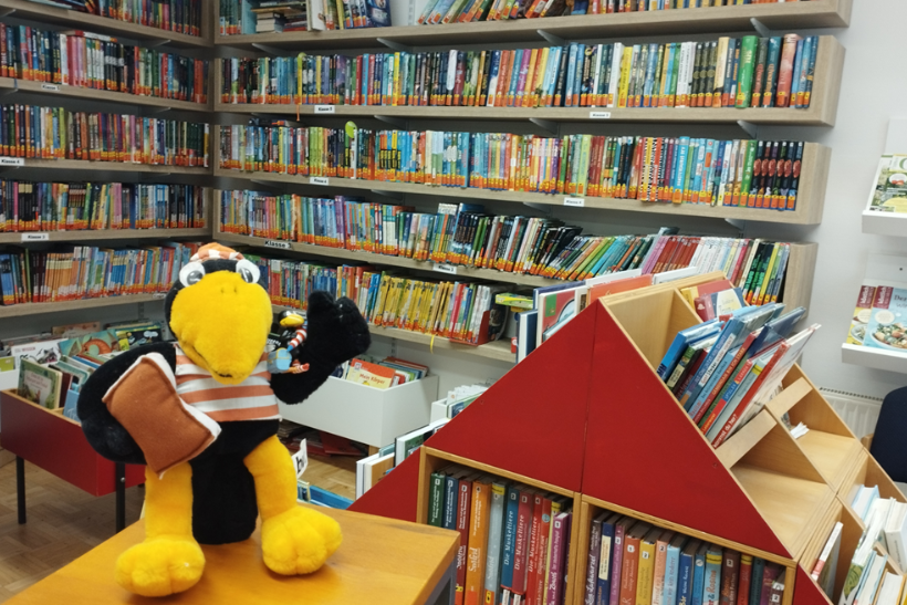 Rabe Fridolin vor Bücherregal