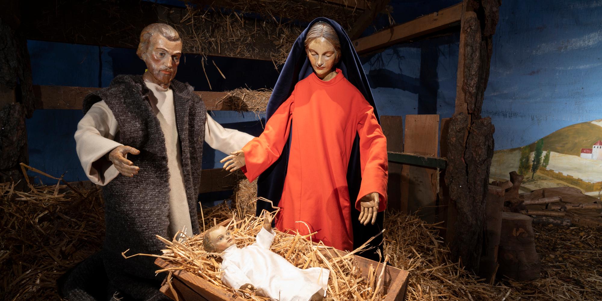 Maria und Josef stehen an der Krippe des Jesuskindes
