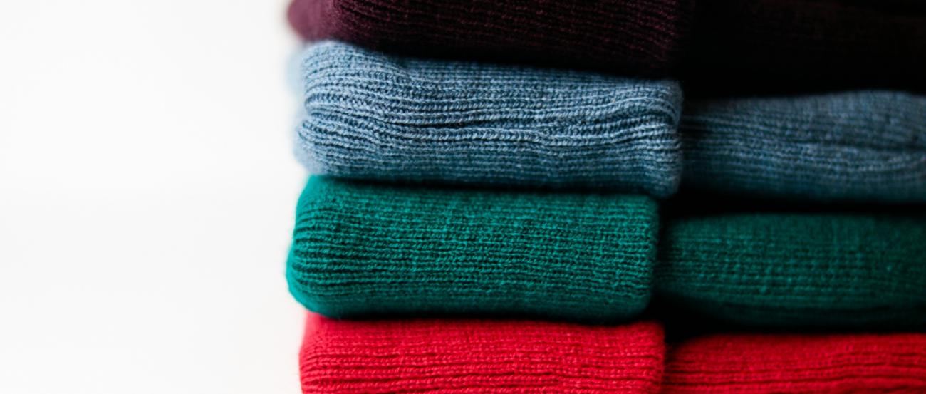 (c) Hamed Darzi | unsplash Farbige Wollmützen gestapelt