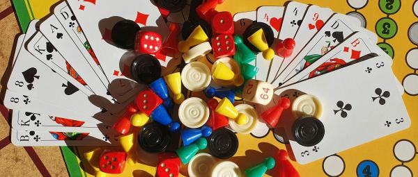 Spielenachmittag (c) unsplash Mensch ärgere dich nicht Spiel mit Person im Hintergrund