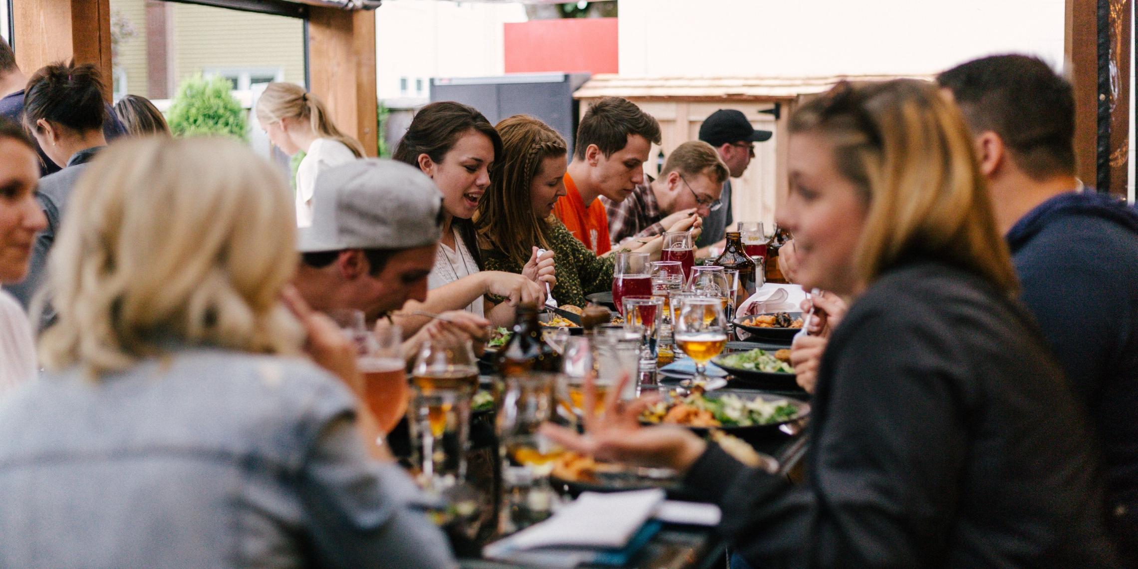 Menschen sitzen bei Essen und Getränken zusammen