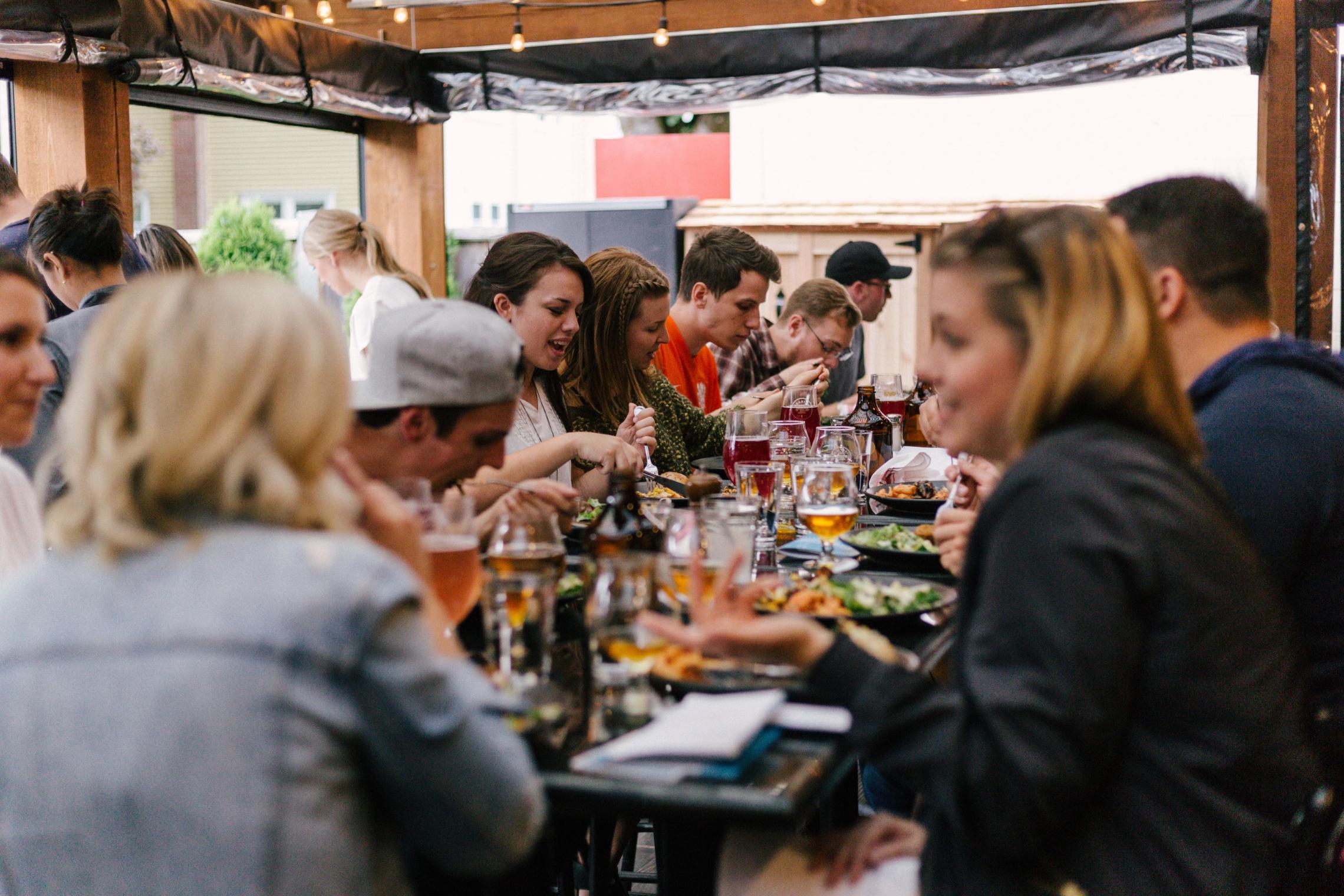 Menschen sitzen bei Essen und Getränken zusammen